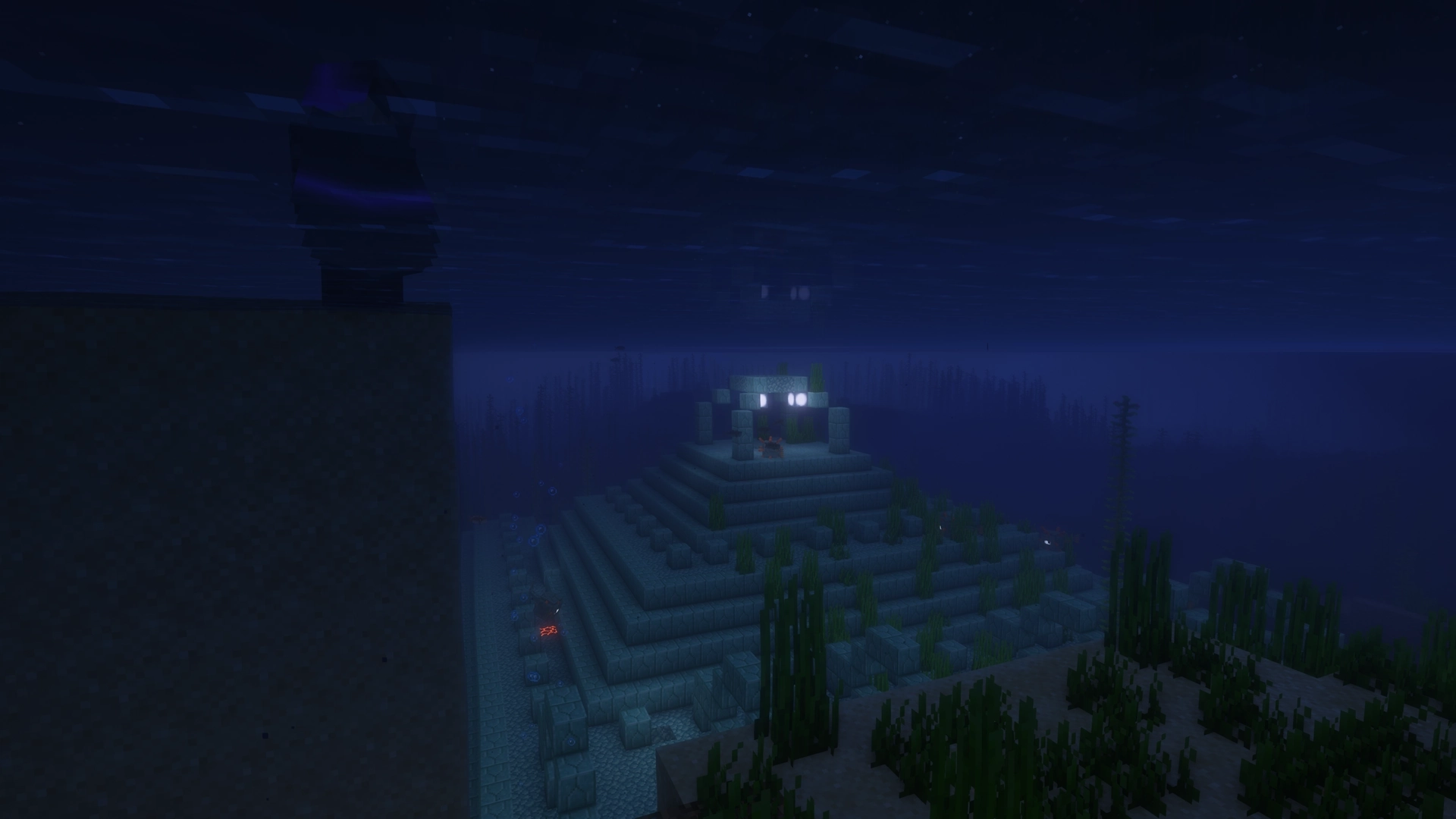 Cinematic night time shot of my character standing on a wall of sand on the close left side of the screen while an Ocean Monument takes up the rest of the bottom half