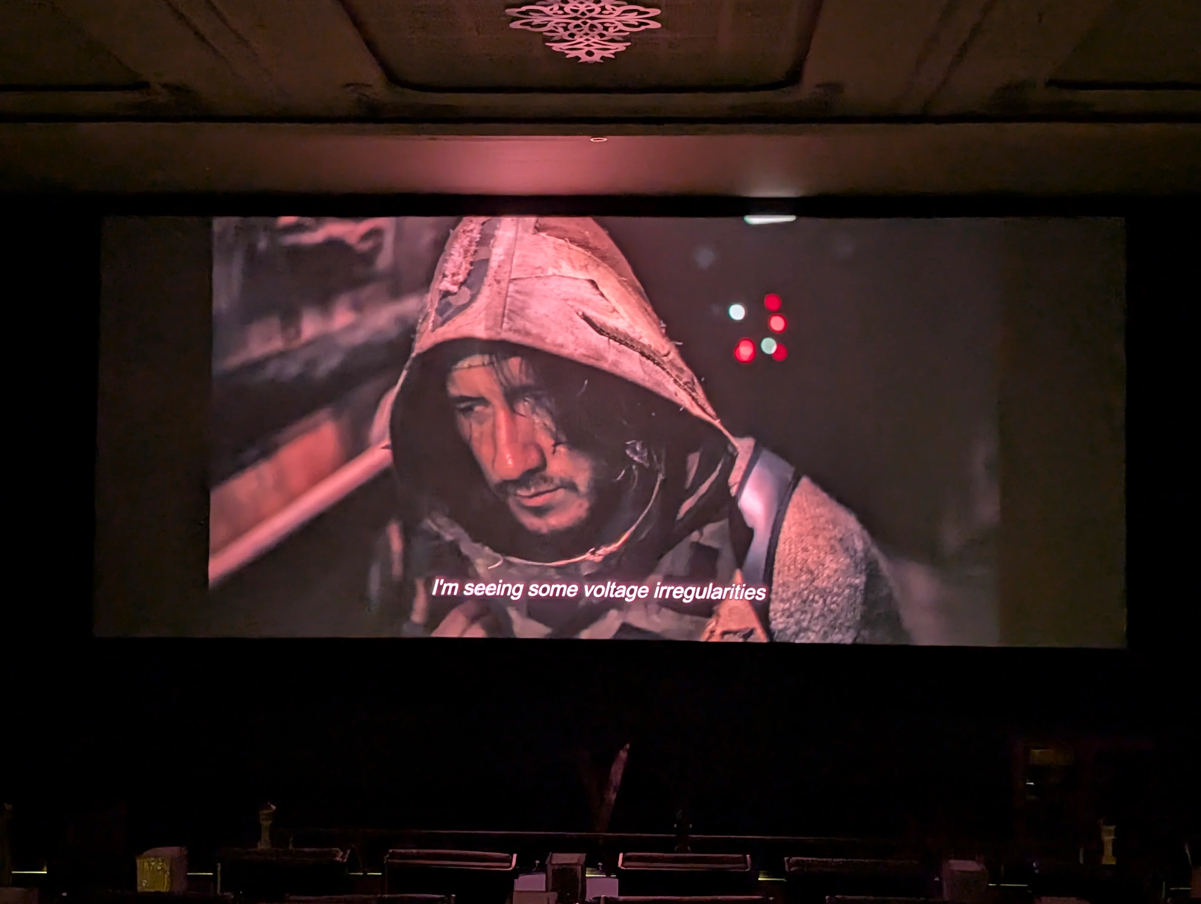 A scene from the movie Iron Lung, showing Markiplier inside a submarine. The subtitle reads "I'm seeing some voltage irregularities".